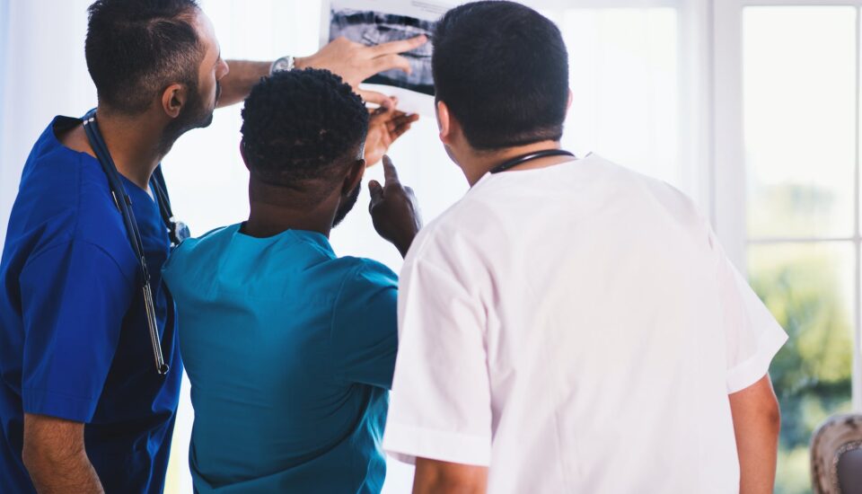three person looking at x ray result