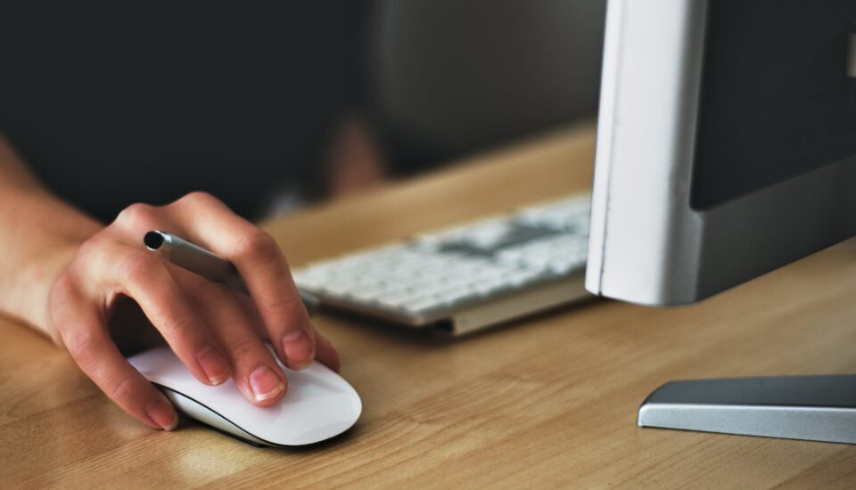 person holding apple magic mouse